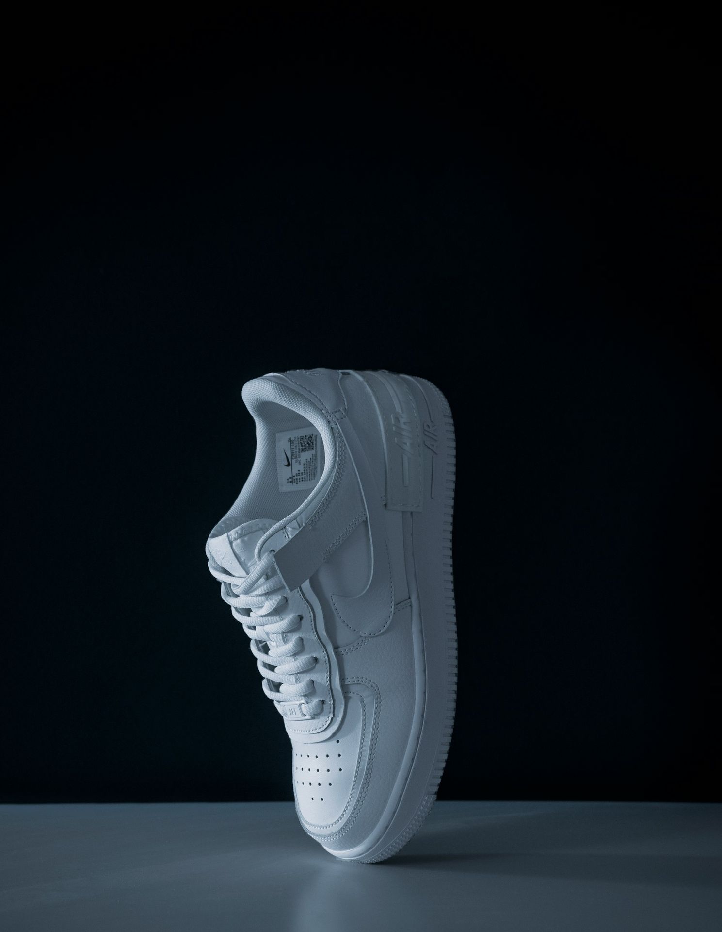 a white shoe on a black background
